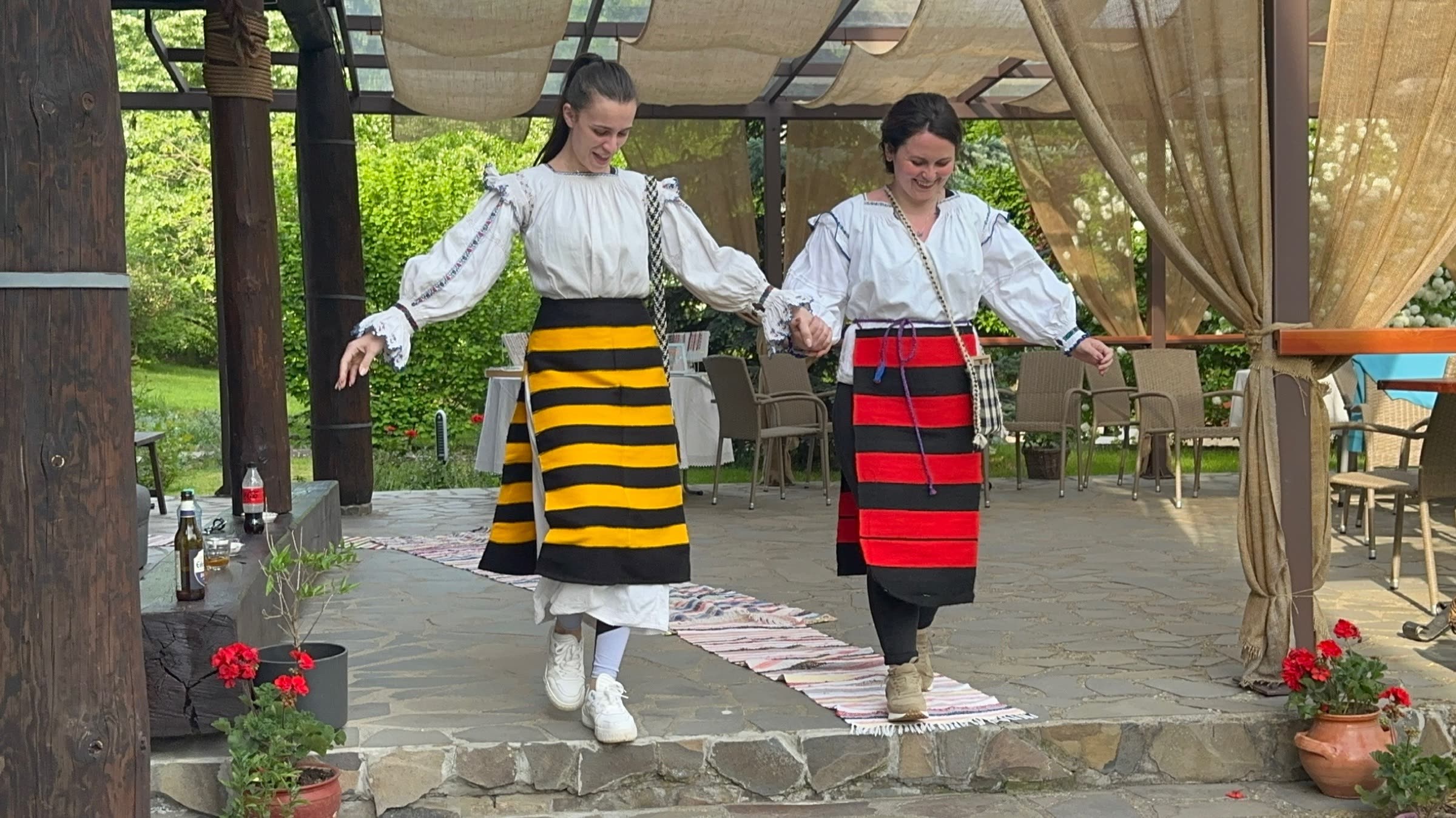 Dansatoare în costume tradiționale, la pergolă
