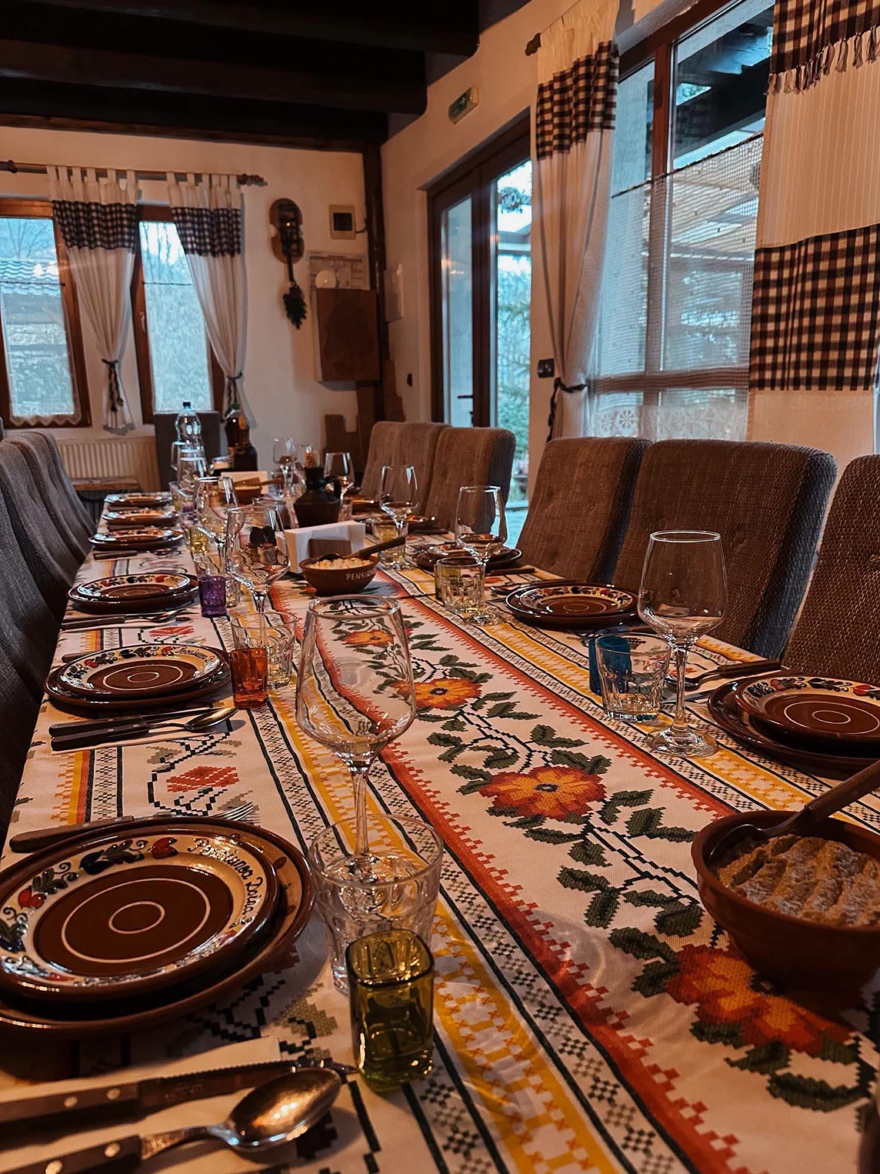 Masă festivă în sala de ospețe, cu boluri și tacâmuri
