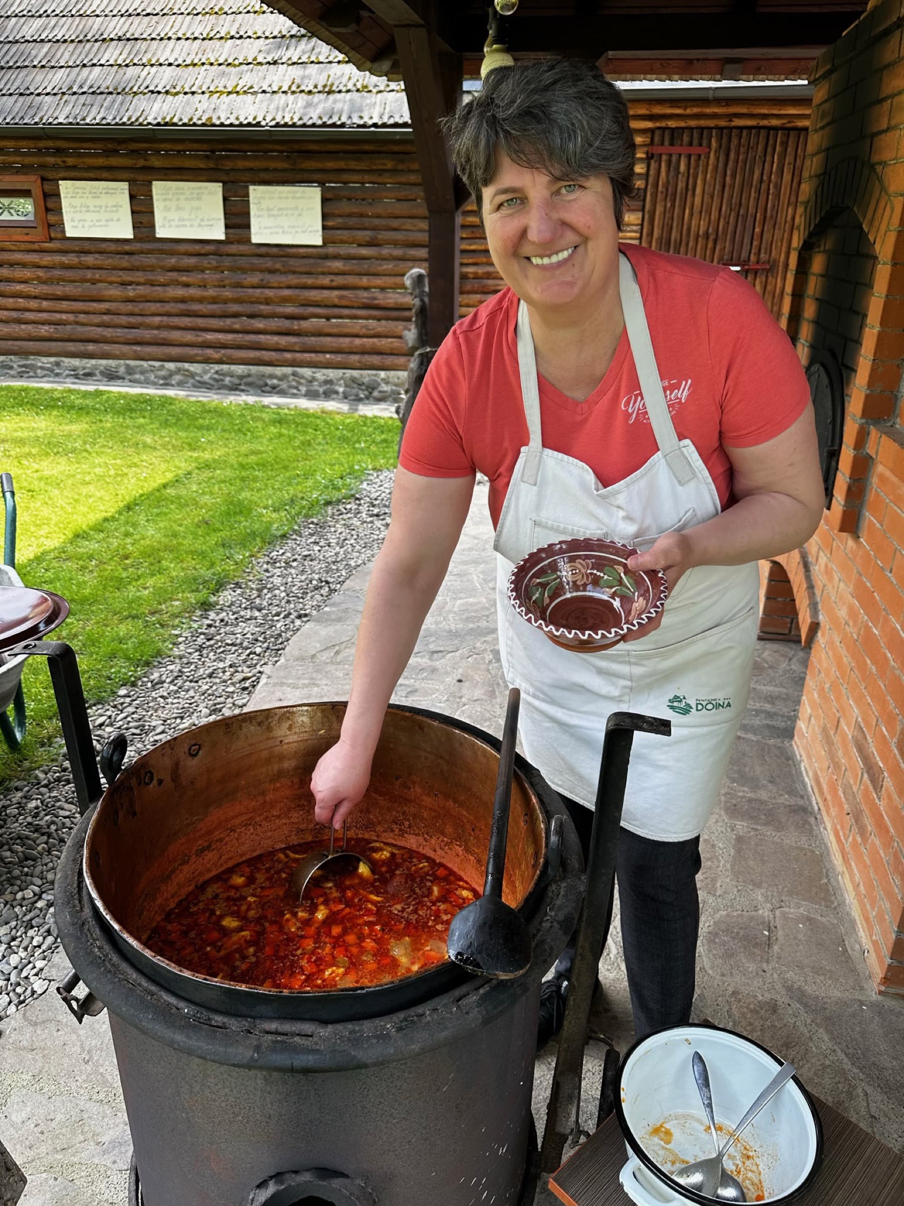 Doina gătind la ceaun, în curte