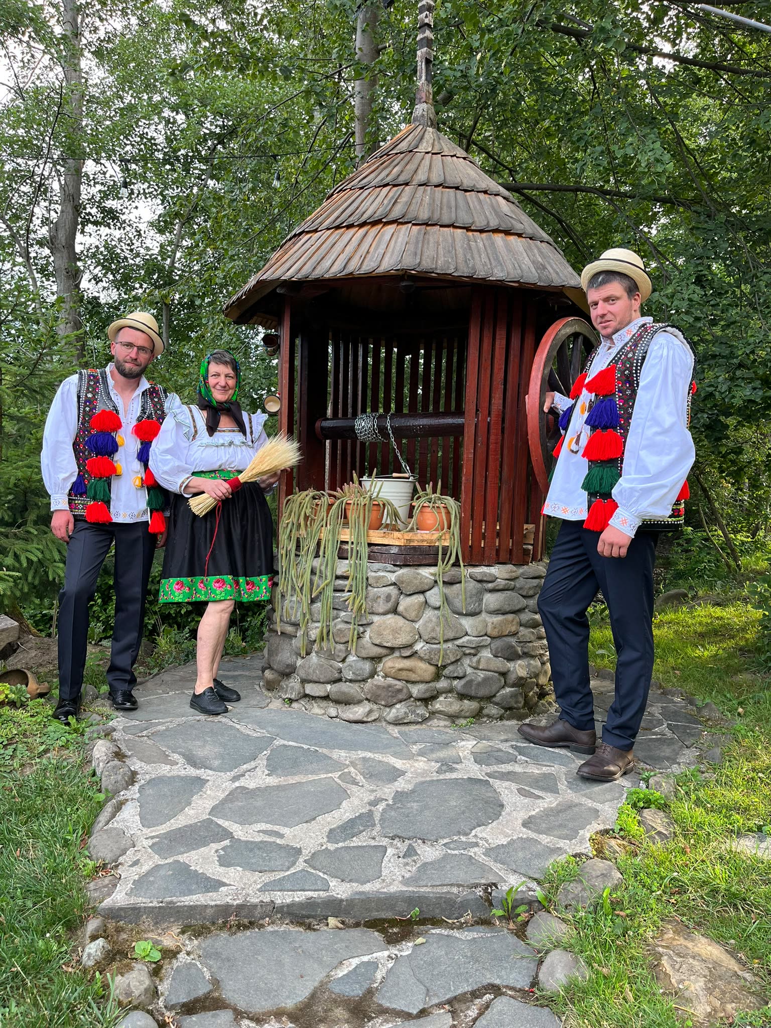 Doina și feciorii ei, Paul și Robert, în straie de sărbătoare, la fântâna din curte