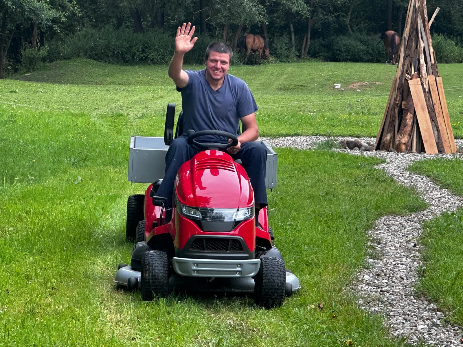 Paul salutând din capătul livezii, de la volanul tractorului